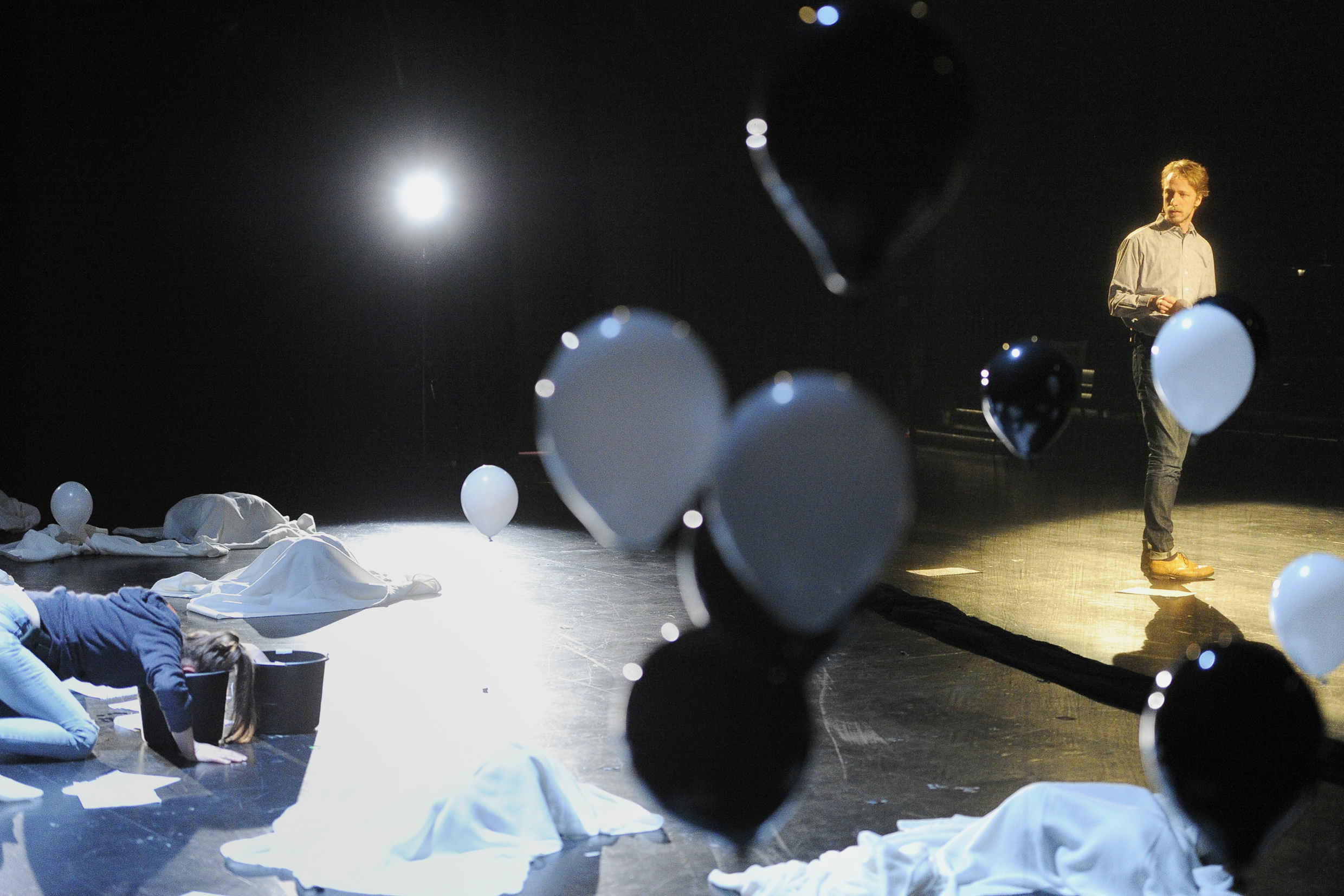 Eine Schauspielerin steht auf der Bühne, umgeben von Luftballons