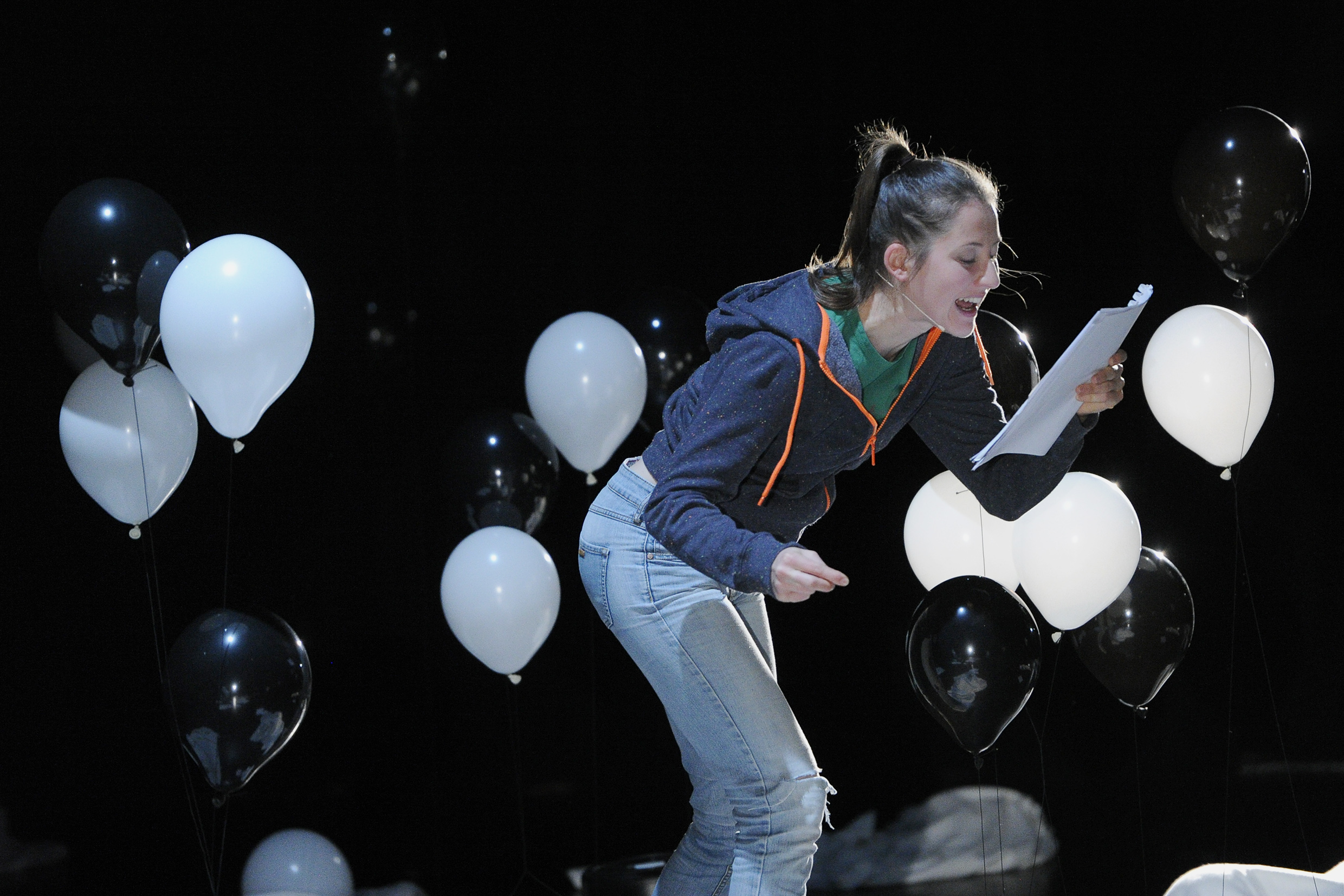 Die Schwester ruft etwas heraus und ist umgeben von schwarzen und weißen Luftballons