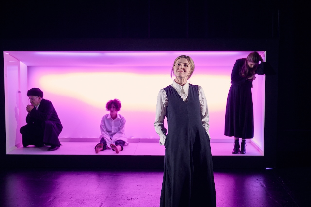 Familie Singer vor Haus in rosa Licht