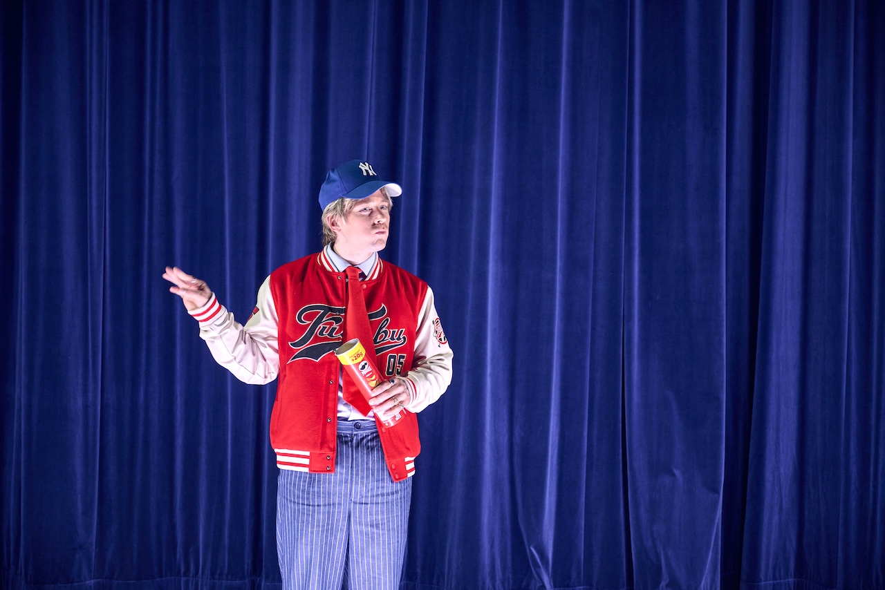 Mac in Baseballjacke und Schildkappe