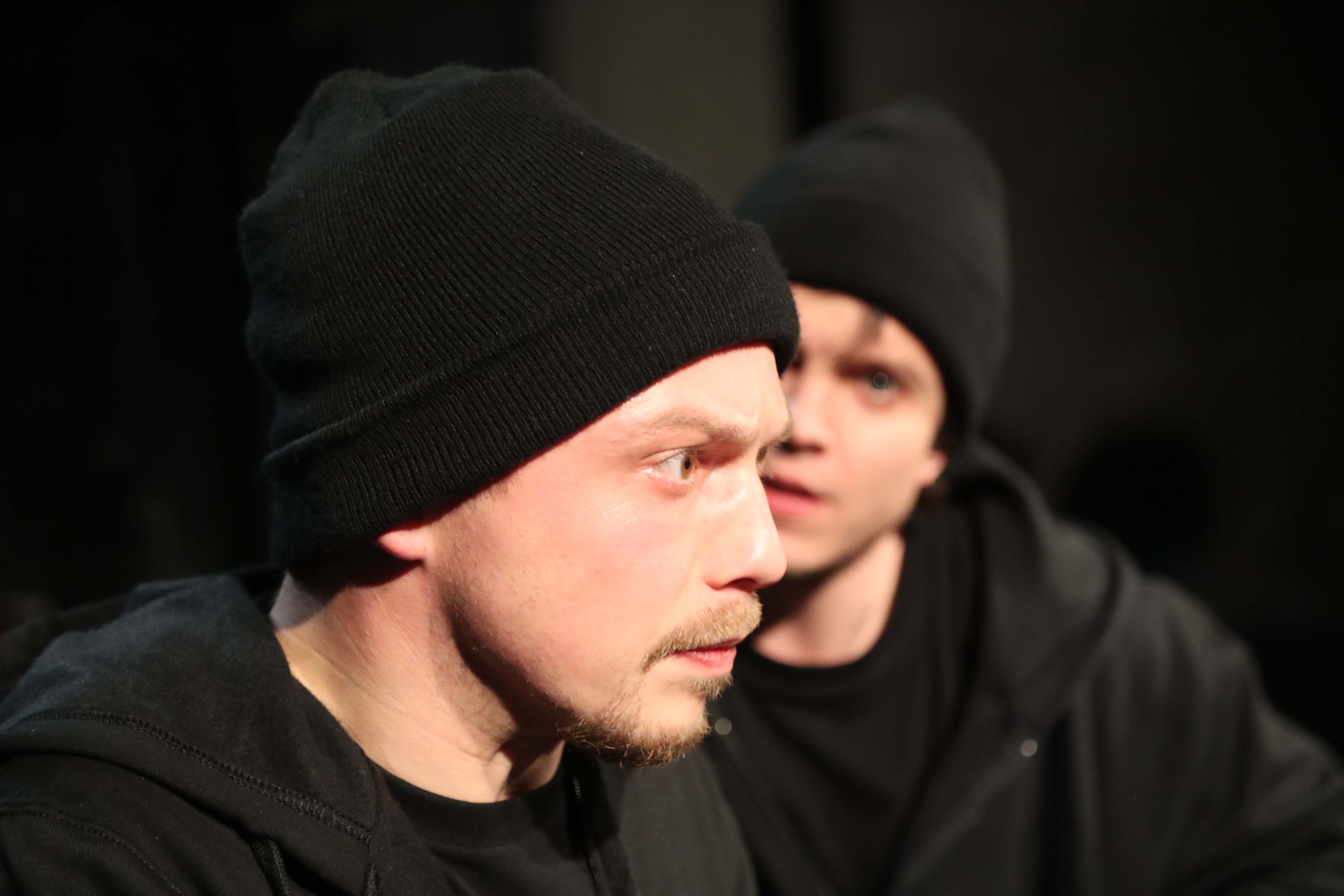 Zwei Darsteller von Jona, ganz in schwarz gekleidet, im Zwiegespräch