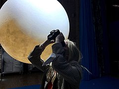 Eine Frau blickt mit einem Fernglas zum Mond