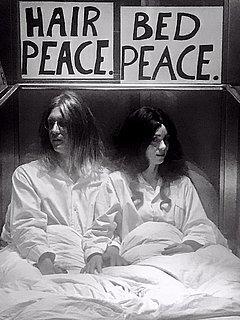 Zwei Schauspieler, die John Lennon und Yoko Ono darstellen, sitzend im Bett